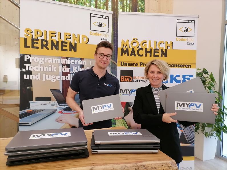 Zwei Personen präsentieren Laptops vor CoderDojo Steyr Rollups