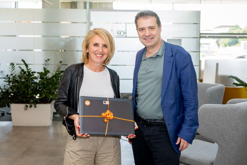 Daniela Zeiner hält einen Laptop in der Hand und posiert mit Markus Knasmüller für ein Foto