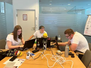 Drei Lehrlinge beim Programmieren