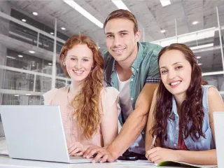 Drei Lehrlinge an einem Laptop