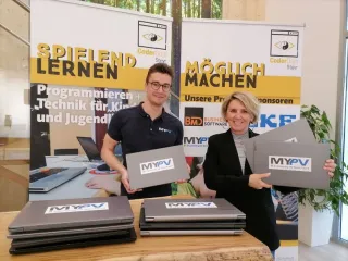 Zwei Personen präsentieren Laptops vor CoderDojo Steyr Rollups
